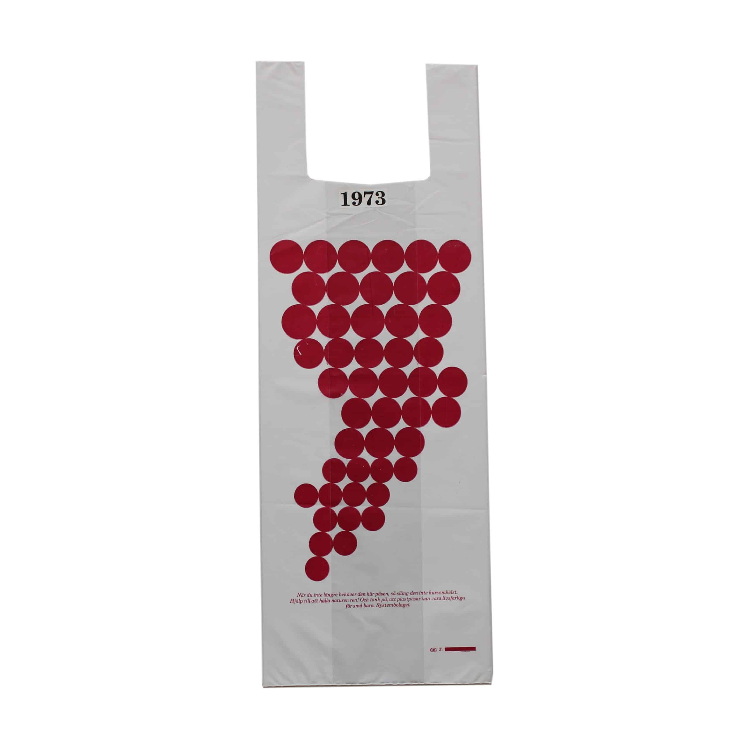 Vit plastpåse med grönt och rött tryckDruvklasar (fokus på vin).Tidpunkt: 1973; Deponent: Systembolaget / Systembolaget AB; Motiv-ID: SYS010018